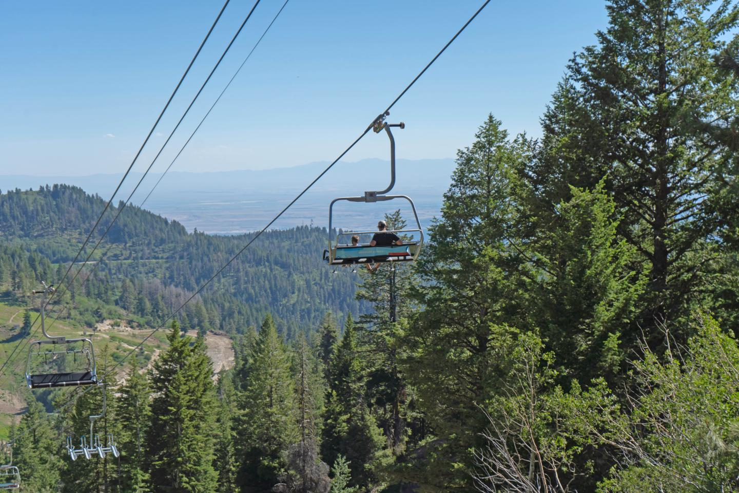 A person riding a chairlift in summer