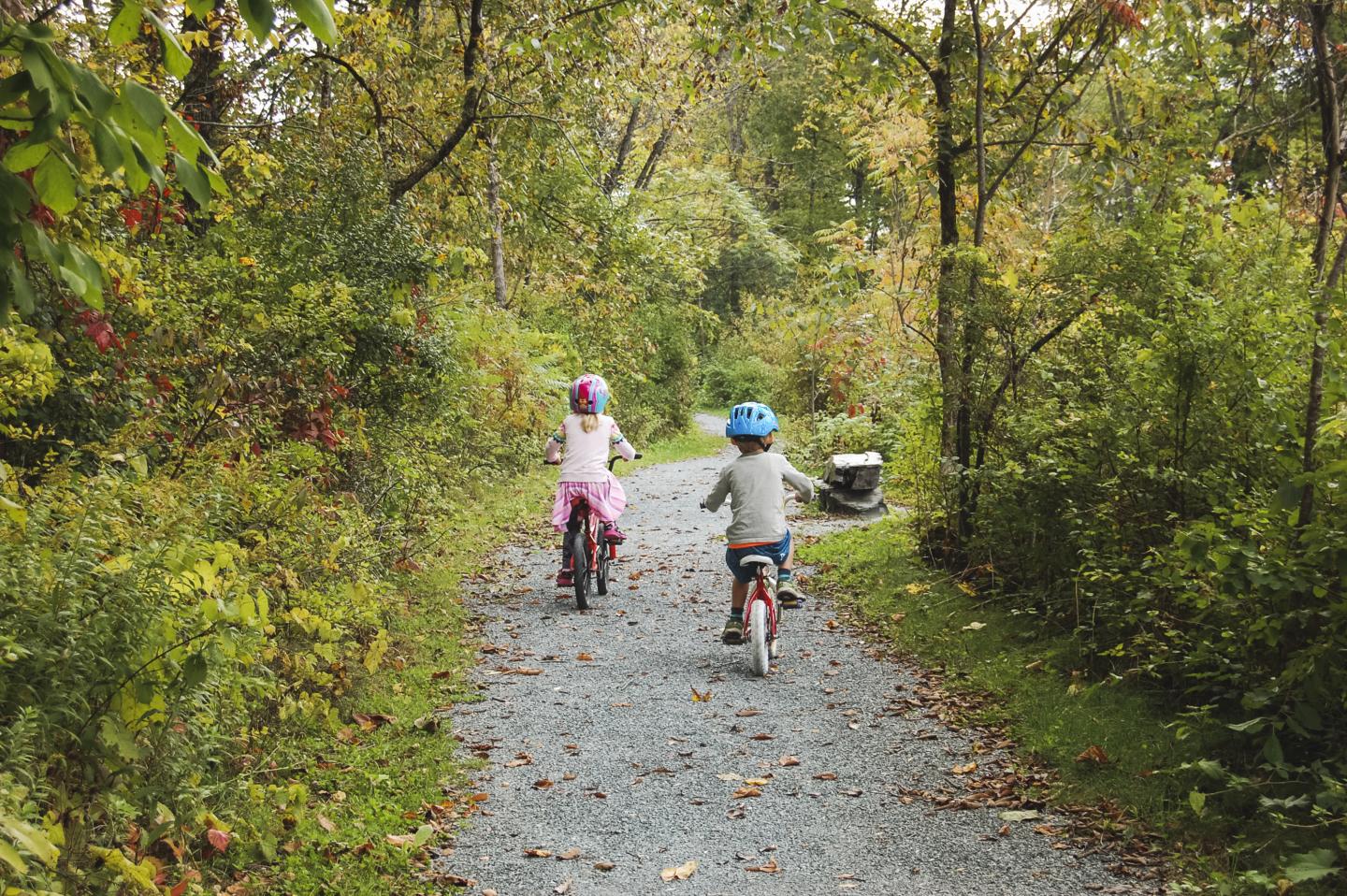 Two kids biking along a trail
