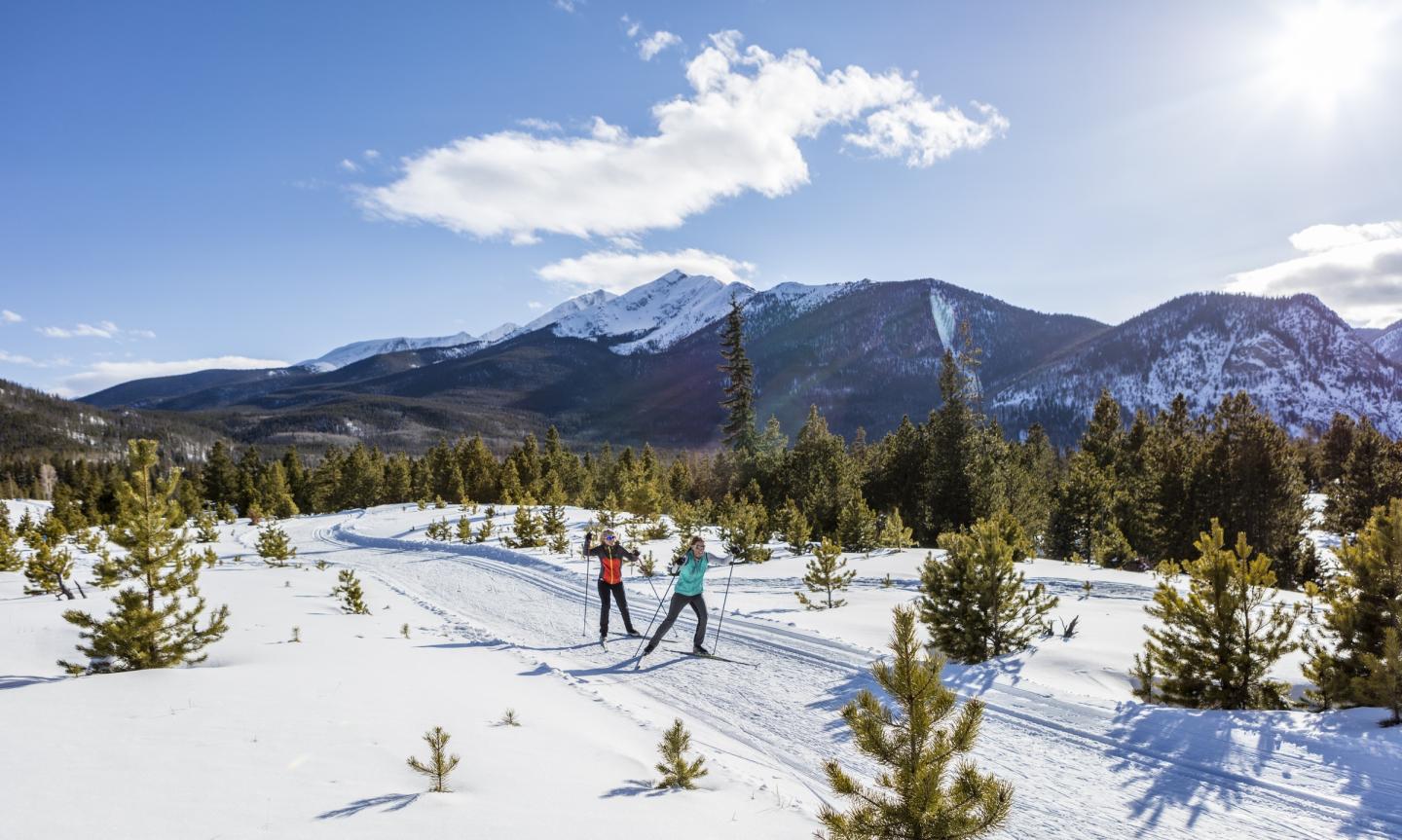 Two people cross country skiing in the mountains