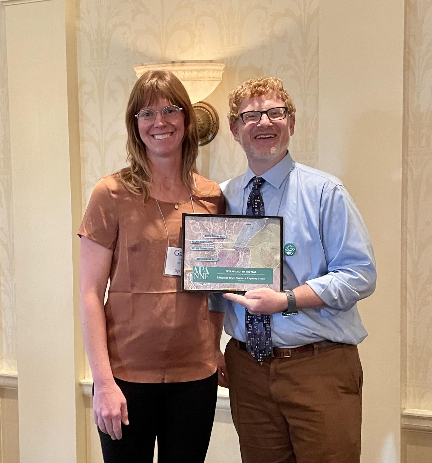 Two people holding an award
