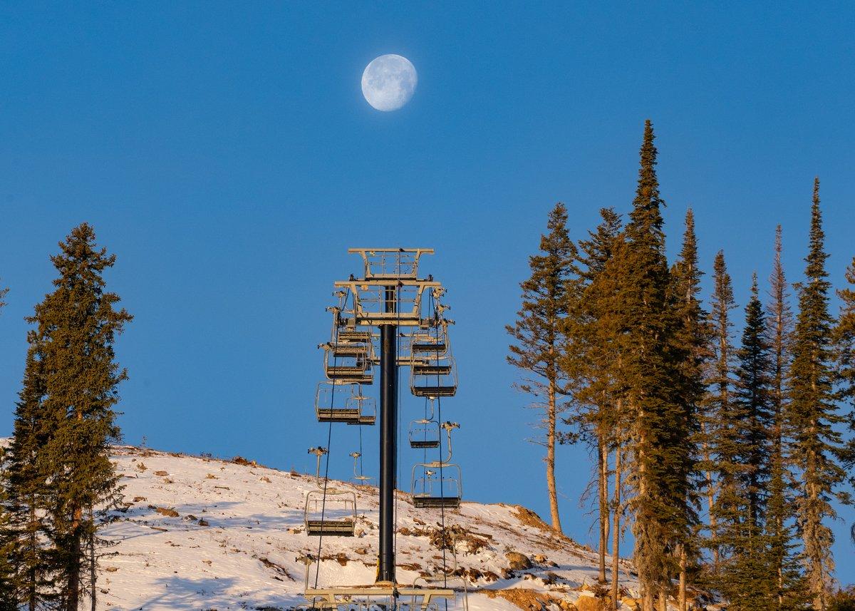 A ski lift with the moon in the background