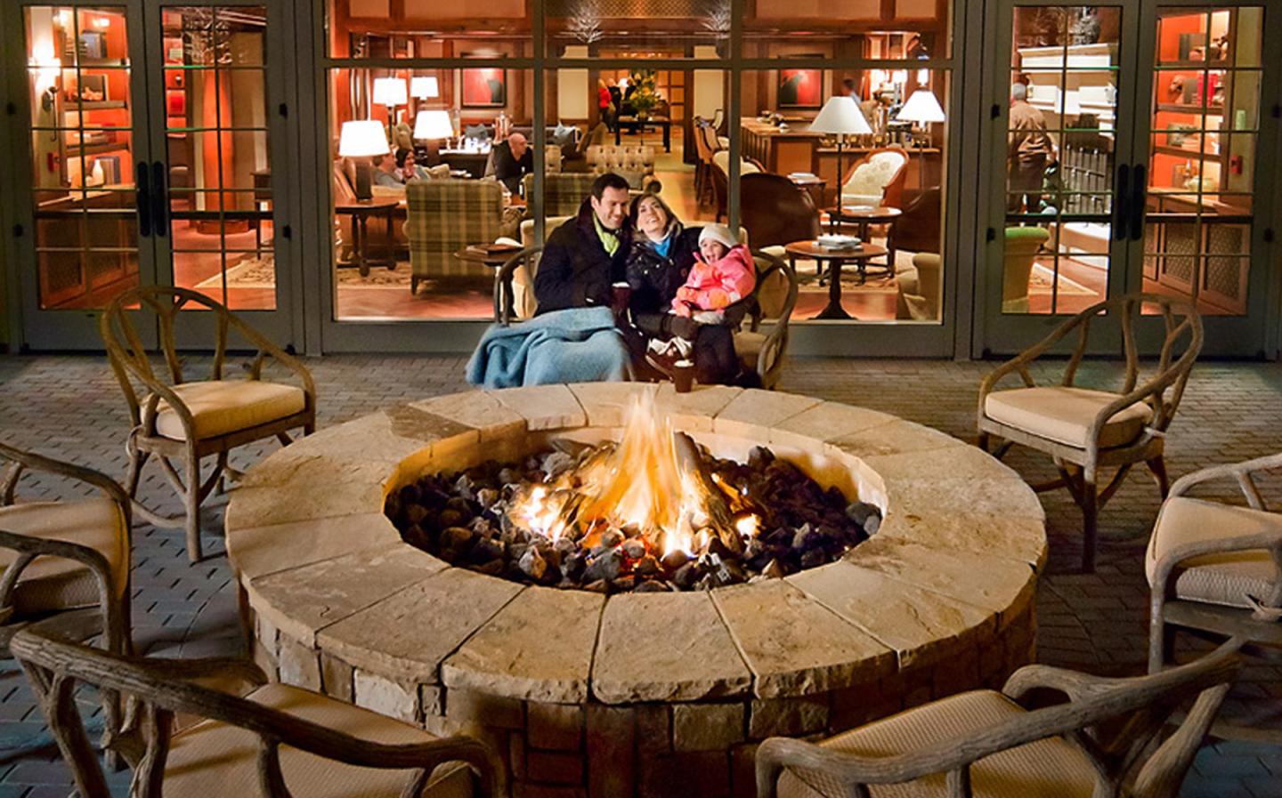 A couple sitting round an outdoor fire pit