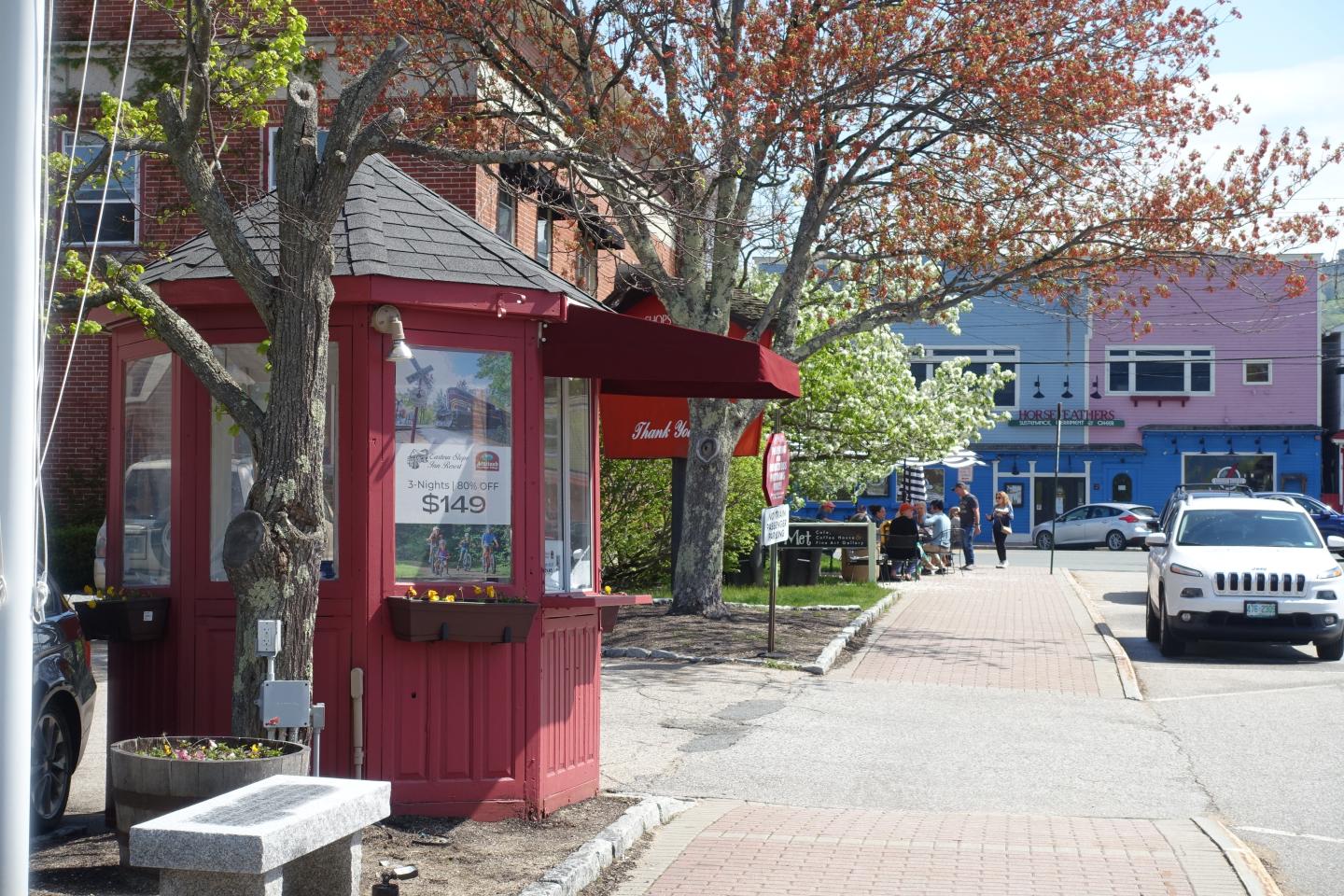 Sidewalk in Conway New Hampshire with a red visitor information booth.