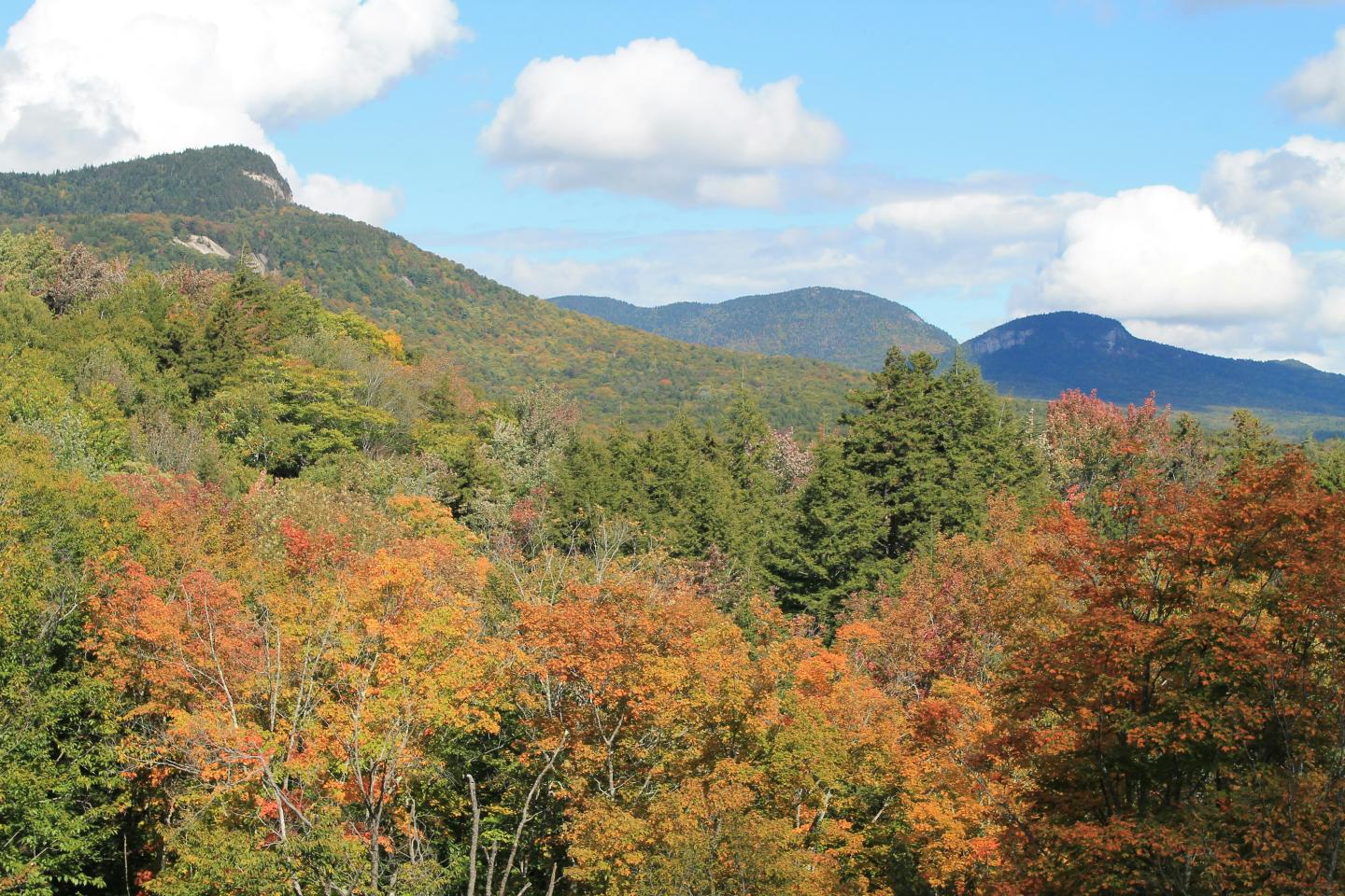 Conway New Hampshire mountains in autumn with blue sky and orange and yellow foliage