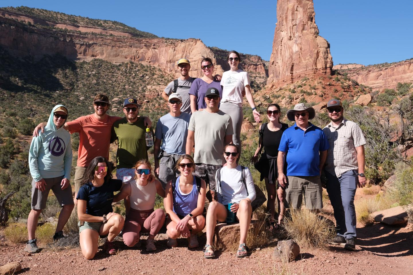 Environmental team smiling in a desert landscape with rock formations.