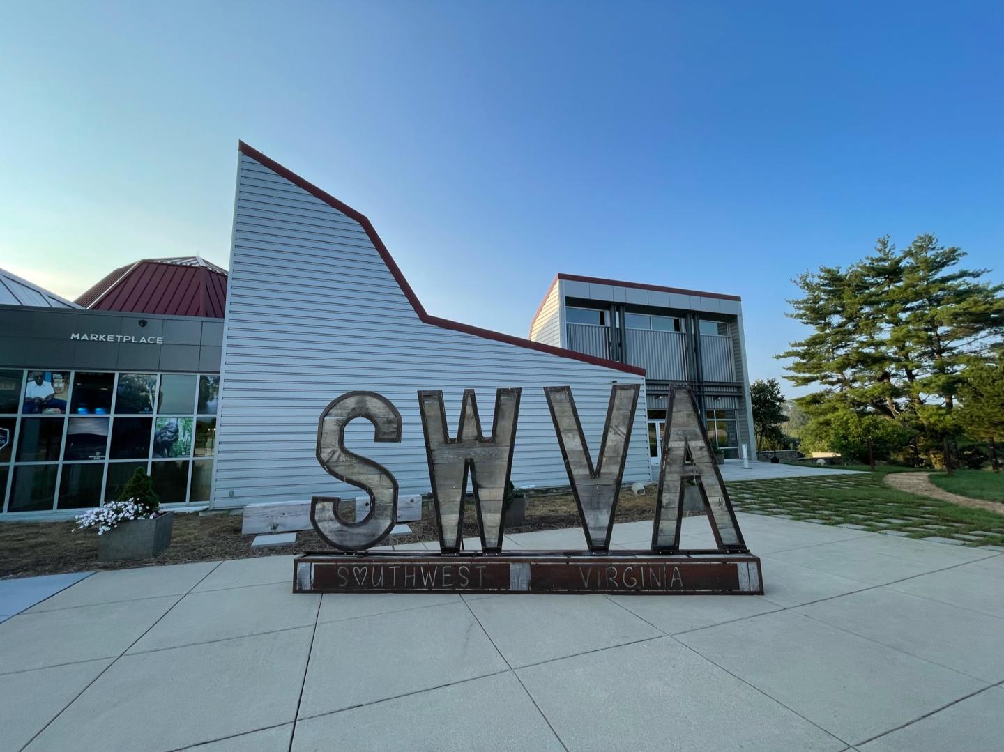 SWVA sign outside a modern building, concrete pathway, clear blue sky.